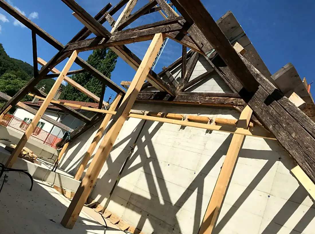 Charpente ancienne conservée sur une structure en béton neuf