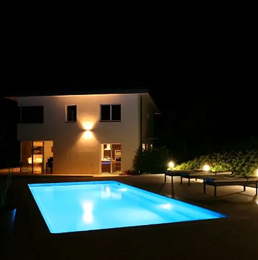 Piscine de nuit, Bassin béton et plages.